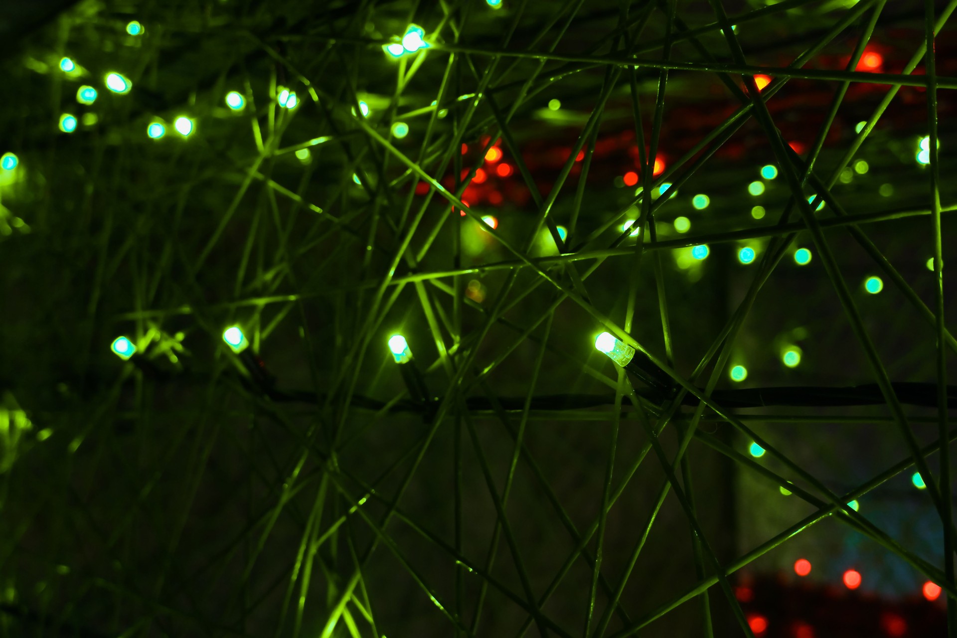 Christmas Background. Garland lights New Year's illumination on the Christmas tree. Abstract Blurred photo background with blinking lights from tangled garlands. winter and holidays background